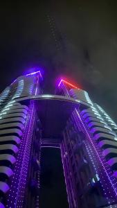 a tall building with purple lights on it at night at LUX Deniz Manzaralı Tuzlu Havuz Su tadını çıkarın. in Konak