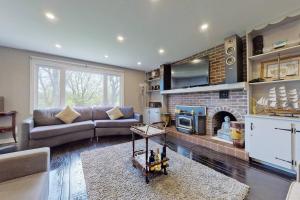 a living room with a couch and a fireplace at Hidden Farm Escape in the Heart of Kawarthas in Beaverton