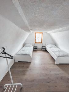 a attic room with two beds and a chair in it at Unterkunft SL in Freimersheim