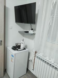 a small refrigerator with a television on top of it at Happy room in Karlovac