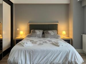 ein Schlafzimmer mit einem Bett mit weißer Bettwäsche und zwei Lampen in der Unterkunft Belle Maison VUT-LE-779 in León