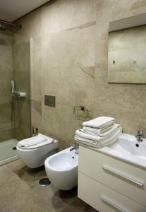 a bathroom with a sink and a toilet and a shower at Lisbon Tagus River - Almada in Almada