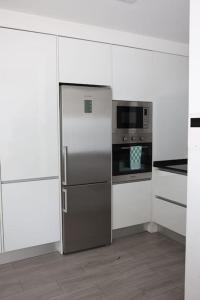 a kitchen with a stainless steel refrigerator and a microwave at Lisbon Tagus River - Almada in Almada