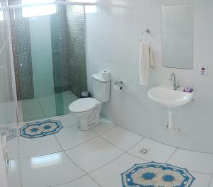 a bathroom with a toilet and a shower and a sink at Pousada Recanto da Preguiça in Jarinu
