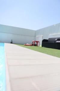 a view of a pool with a red chair next to it at Lisbon Tagus River - Almada in Almada