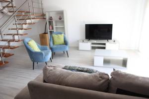 a living room with a couch and chairs and a television at Lisbon Tagus River - Almada in Almada