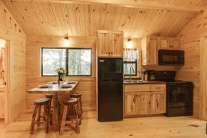 a kitchen with a black refrigerator and a table at Middlebury Center Retreat Gas Grill and Scenic Deck 