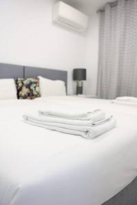 a white bed with two white towels on it at Lisbon Tagus River - Almada in Almada +29 photos