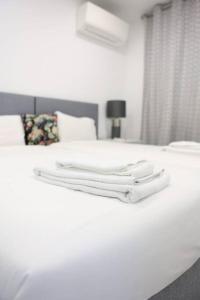 a white bed with two white towels on it at Lisbon Tagus River - Almada in Almada
