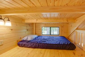 a bed in a log cabin with a window at Scenic Deck and Grill Middlebury Center Retreat! in Middlebury Center