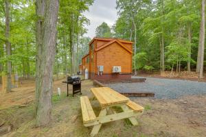 a cabin in the woods with a picnic table and a grill at Scenic Deck and Grill Middlebury Center Retreat! in Middlebury Center