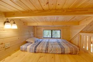 una camera da letto in una baita di tronchi con letto di Tranquil Middlebury Center Cabin with Mountain Views 