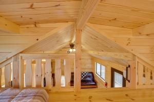 a bedroom in a log cabin with wooden ceilings at Stunning Mtn Views Middlebury Center Retreat! in Middlebury Center