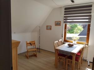 ein Esszimmer mit einem Tisch, Stühlen und einem Fenster in der Unterkunft Hedasis Ferienwohnung3, 500 m zum Möhnesee in Möhnesee