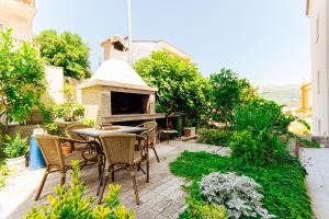 a patio with a table and chairs and a fireplace at Stylish apt Marta, private parking,BBQ in Stobreč in Stobreč