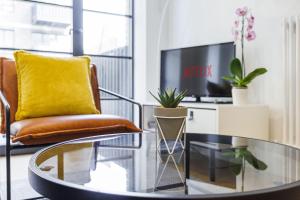 een woonkamer met een glazen tafel en een stoel bij Apartment Near Canary Wharf 02 Arena & Excel in Londen