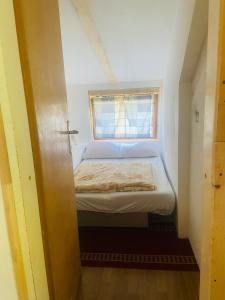 a small bed in a small room with a window at Log cabin 