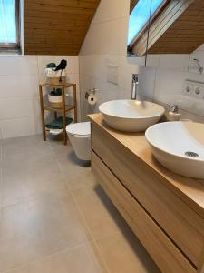 a bathroom with two sinks and a toilet at Vela Ferienhaus in Lichtenstein