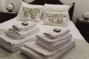 une pile de serviettes assises au-dessus d'un lit dans l'établissement OrlaBela, à Manta Rota
