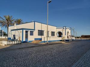 un bâtiment blanc avec un palmier à côté d'une rue dans l'établissement OrlaBela, à Manta Rota