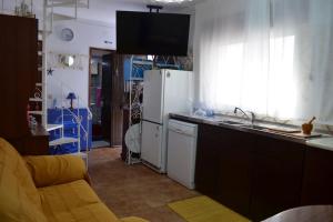 La cuisine est équipée d'un évier et d'un réfrigérateur blanc. dans l'établissement OrlaBela, à Manta Rota