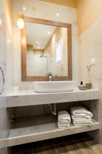 uma casa de banho com um lavatório e um espelho em Venice Deluxe Studios em Pefkari