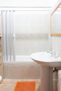 een badkamer met een witte wastafel en een douche bij Comodo appartamento a Crotone in Crotone