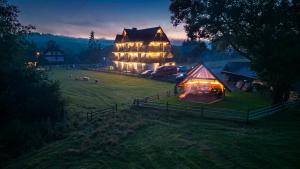 Una casa grande en un campo por la noche en Willa Taterniok - pokoje z widokiem na Tatry, en Czarna Góra