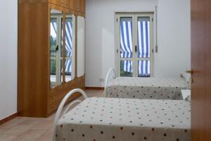 a room with two beds and two windows at Comodo appartamento a Crotone in Crotone