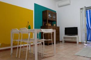 een eetkamer met een tafel en stoelen en een tv bij Comodo appartamento a Crotone in Crotone