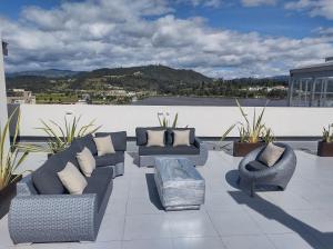 d'une terrasse sur le toit avec des canapés et des chaises. dans l'établissement Hermoso Apartamento frente al lago, à Paipa
