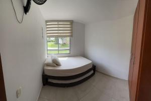 een kleine kamer met een bed en een raam bij Espectacular apartamento Conjunto Piedemonte in Villavicencio