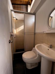 łazienka z toaletą i umywalką w obiekcie Gamora Hotel Playa w mieście Los Órganos