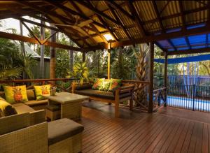 una veranda schermata con divani e tavolo di Villa within walking distance of cable beach Australia a Cable Beach