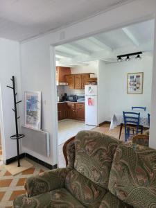 ein Wohnzimmer mit einem Sofa und einer Küche in der Unterkunft La maison rouge paisible maison de pays in Saujon