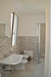 a bathroom with a sink and a toilet and a shower at Home 13 in San Gregorio di Catania