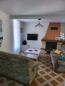 ein Wohnzimmer mit 2 Sofas und einem Kamin in der Unterkunft La maison rouge paisible maison de pays in Saujon