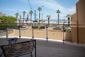 a balcony with a view of the beach and palm trees at Joya Apartment's - Milazzo in Milazzo