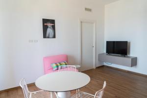 a living room with a table and chairs and a tv at Joya Apartment's - Milazzo in Milazzo
