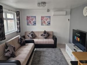 a living room with a couch and a tv at Perfect for exploring Birmingham in Birmingham