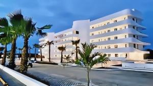 a large white building with palm trees in front of it at Cana Rock Star Pool View Whith BBQ - Star C-305 in Punta Cana