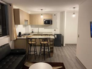 a kitchen with a table and some bar stools at Edificio Lynch Iquique in Iquique