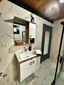 a white bathroom with a sink and a mirror at Sapanca Aslan dağevi in Sapanca