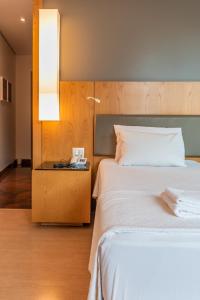ein Hotelzimmer mit 2 Betten und einer Lampe in der Unterkunft DELPLAZA Marabá São Paulo in São Paulo