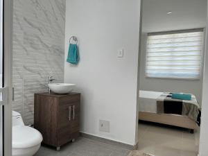 La salle de bains est pourvue de toilettes, d'un lavabo et d'un lit. dans l'établissement Cerca del Paraíso, Río Guatapuri, à Valledupar