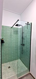 a bathroom with a shower with green tile at Loft el Baix - Cullera in Cullera