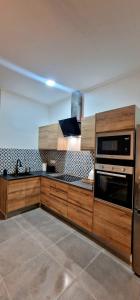 a kitchen with wooden cabinets and a stove top oven at Loft el Baix - Cullera in Cullera