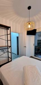 a bedroom with a bed and a chandelier at Loft el Baix - Cullera in Cullera