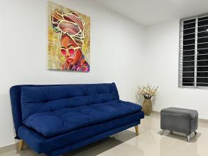 un divano blu in soggiorno con un dipinto di Río Guatapuri y Confort Deluxe a Valledupar