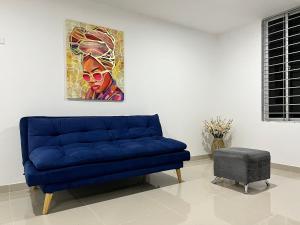 a blue couch in a room with a painting on the wall at Río Guatapuri y Confort Deluxe in Valledupar